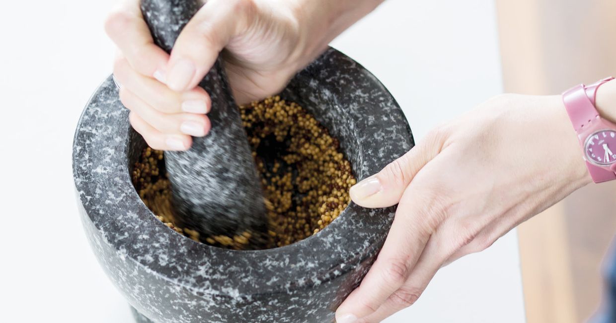 Ucieranie ziaren na musztardę w moździerzu (fot. dinnershow studio)