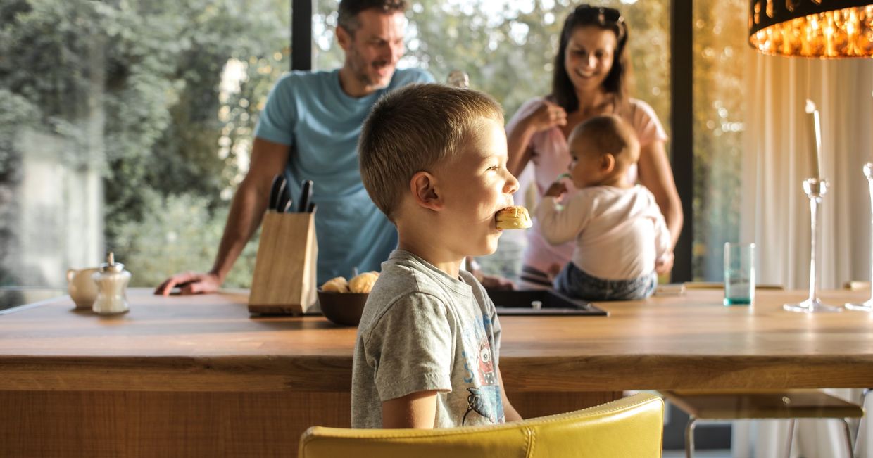 Dzieci jedzą słodycze z rodzicami w kuchni (fot. Cottonbro / pexels.com)