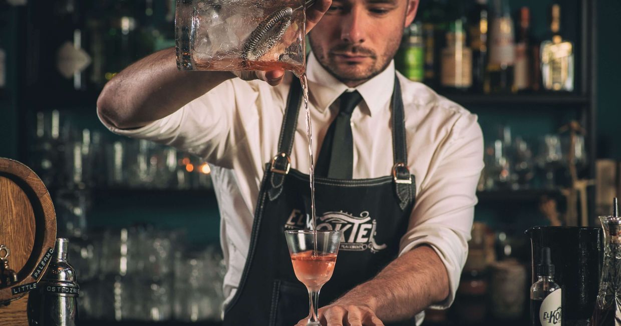 Paweł Rodaszyński, właściciel baru El Koktel podczas pracy w barze, nalewa zrobiony przez siebie koktajl do kieliszka