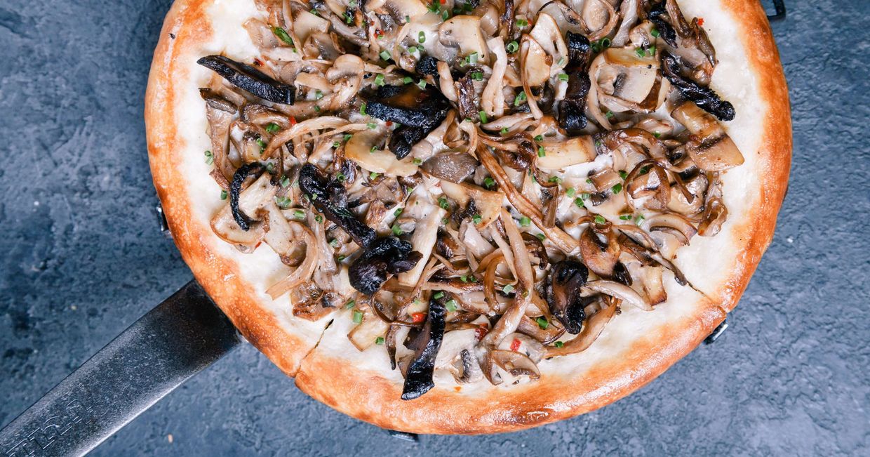 Pizza z grzybami podana na metalowej patelni (fot. Anastasiia Vasileva)