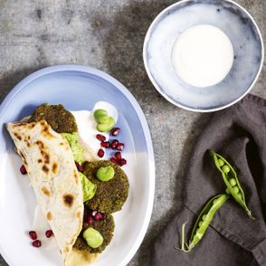 Falafele z bobu i ciecierzycy z domowym
podpłomykiem, pestkami granatu i tahiną (fot. dinnershow.studio)