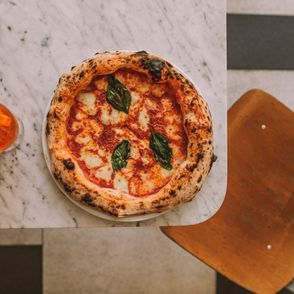 Pizza z bazylią, krzesło, blat marmurowy