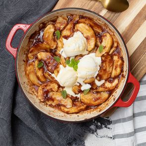 Pieczone kawałki jabłka z cynamonem i lodami waniliowymi w czerwonym naczyniu żaroodpornym (fot. Paulina Czyżewska)