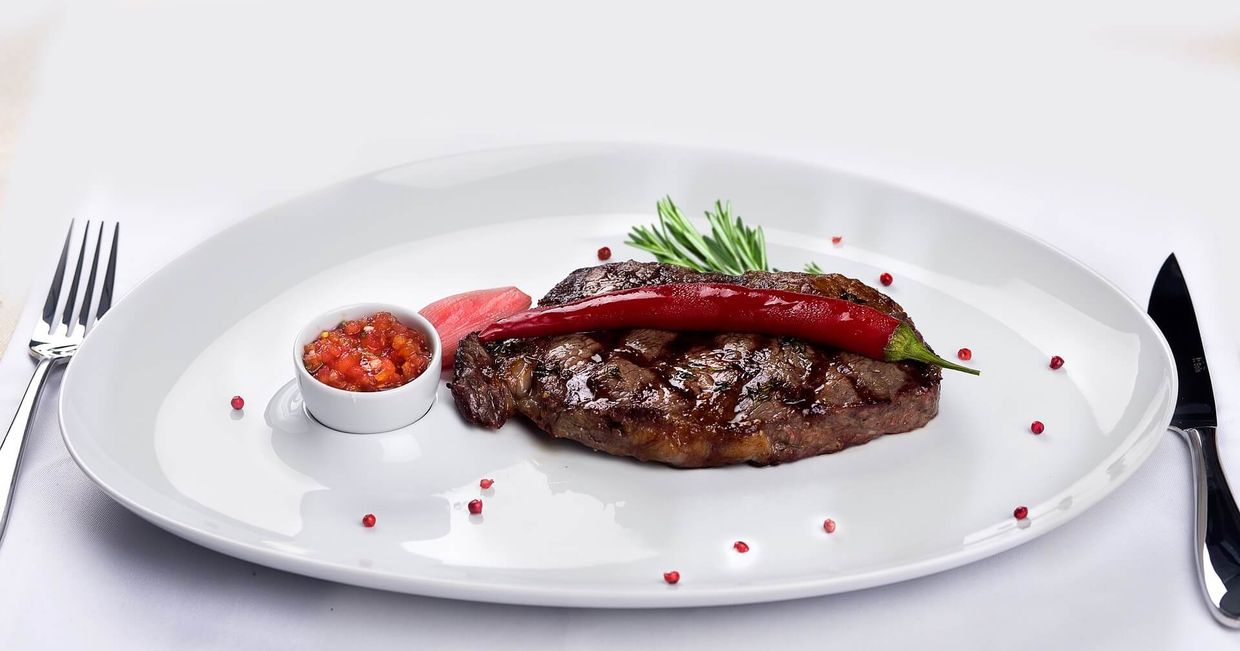 Stek na talerzu z papryczką chili i salsą (fot. m4muli / pixabay.com)