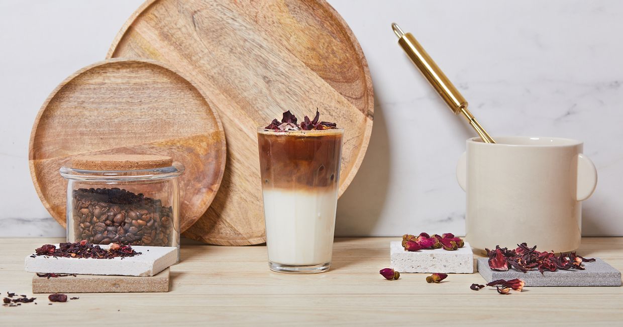 Mrożone latte z wodą z kwiatów pomarańczy w wysokiej szklance, płatki kwiatów, ubijaczka do mleka (fot. Maciek Niemojewski)