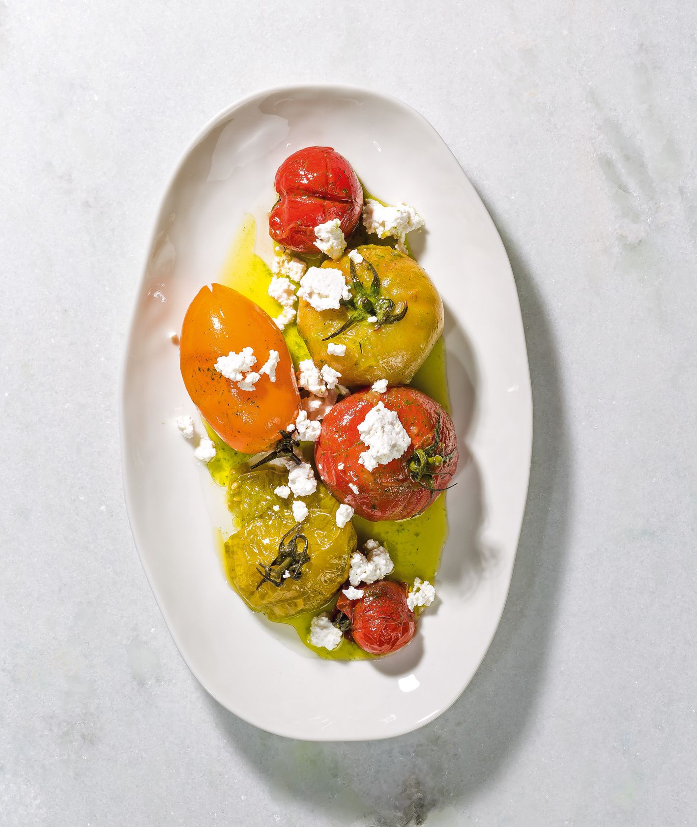 Prosty przepis na pyszne pomidory marynowane w oliwie ziołowej podawane z twarogiem (fot. dinnershow.studio)