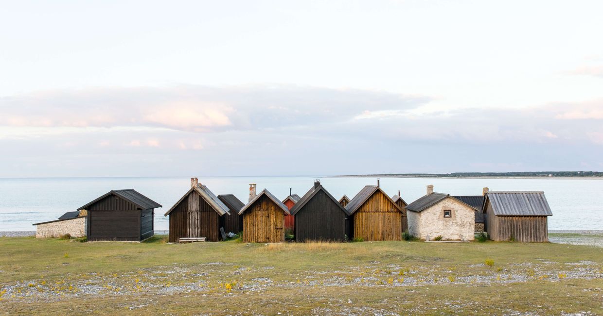 Surowe, drewniane domki nad wodą w Skandynawii (fot. Jon Flobrant)