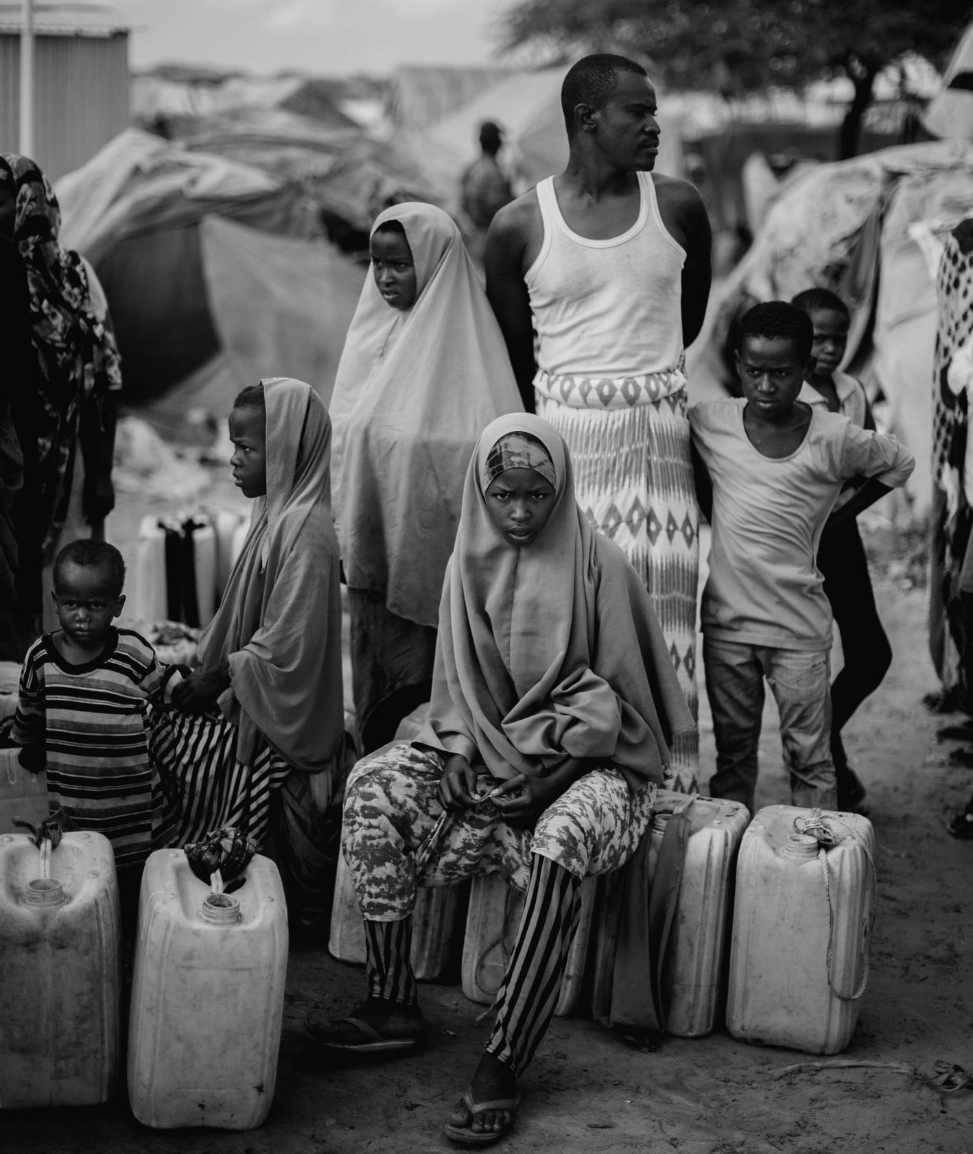 Ludzie czekający w kolejce do ujścia wody w jednym z obozów położonych na obrzeżach stolicy Somalii. Fragment materiału realizowanego dla PAH. Somalia 2018. RAST agencja fotograficzna (fot. Filip Skrońca)