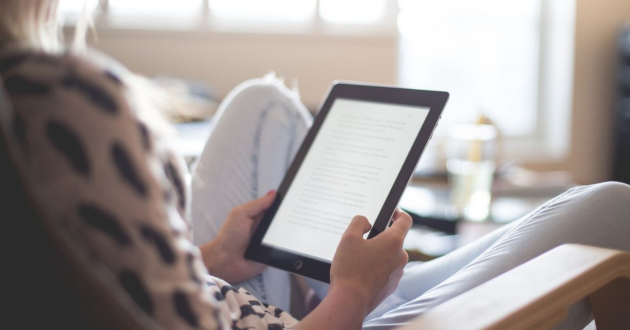 Kobieta czytająca e-booka na czytniku (fot. Pexels)