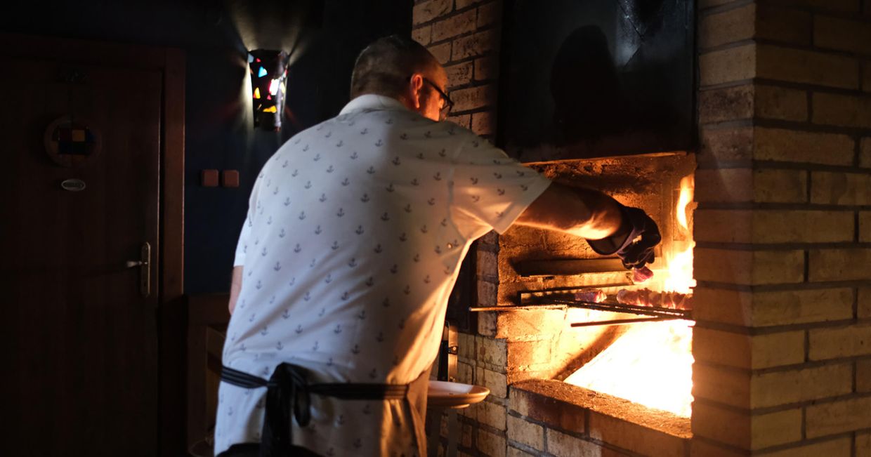 Mężczyzna smażący mięsne szaszłyki na grillu (fot. Aleksander Szojer)