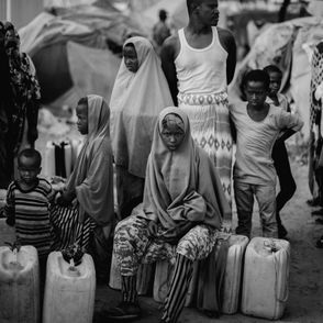 Ludzie czekający w kolejce do ujścia wody w jednym z obozów położonych na obrzeżach stolicy Somalii. Fragment materiału realizowanego dla PAH. Somalia 2018. RAST agencja fotograficzna (fot. Filip Skrońca)
