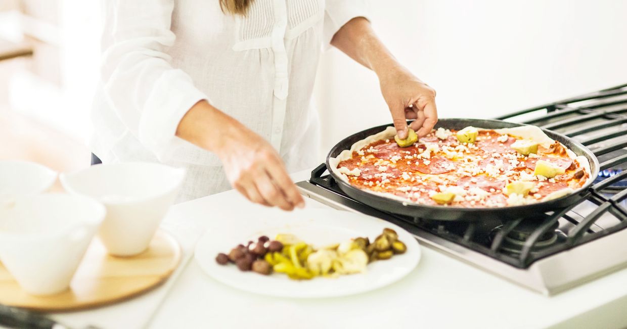 Układanie składników na pizzy (fot. Dinnershow Studio)