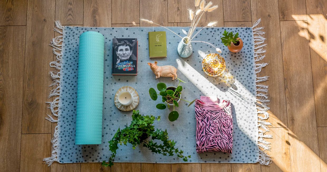 Dywanik, mata do jogi, filiżanka i figurka świnki - zestaw ulubionych przedmiotów ułożonych na podłodze (fot. Mari Krystman)