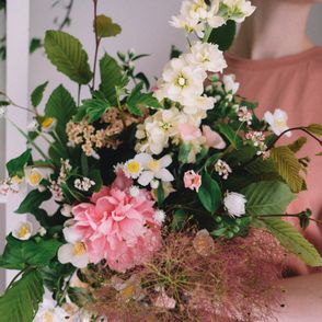 Bukiet biało różowych kwiatów, trzymany przez kobietę w różowej bluzce (fot.Peter Bucks / unsplash.com)