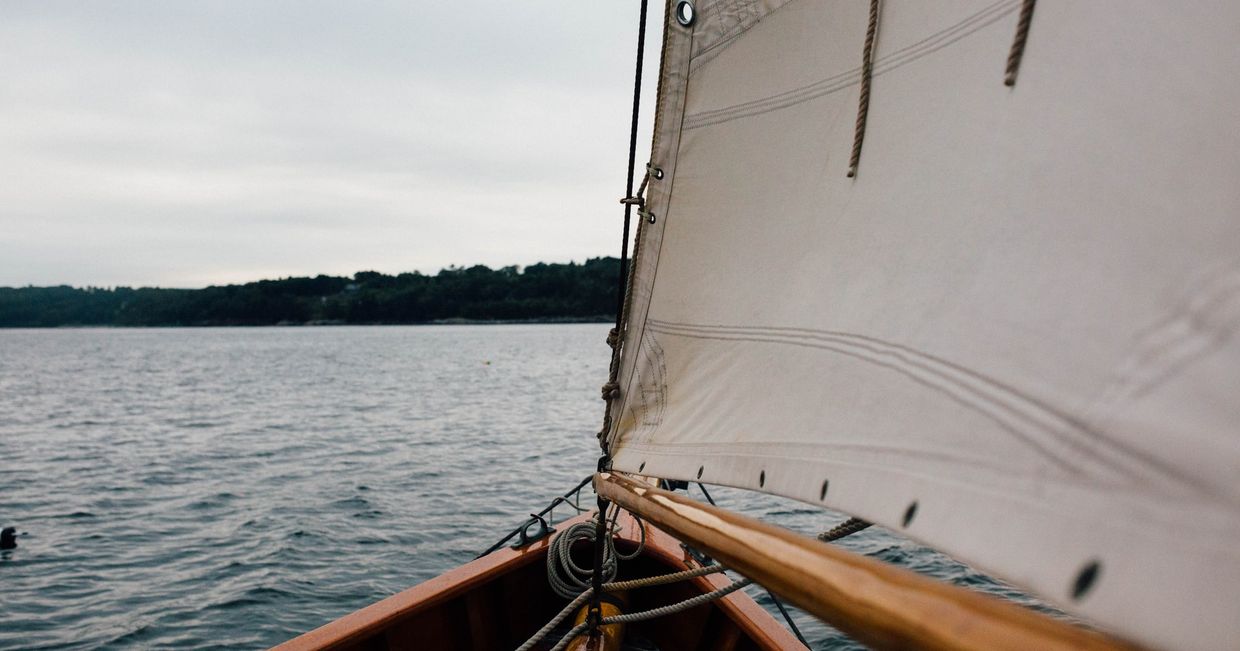 Maszt na dziobie żaglówki – żeglowanie po jeziorze (fot. Sonja Langford / unsplash.com)