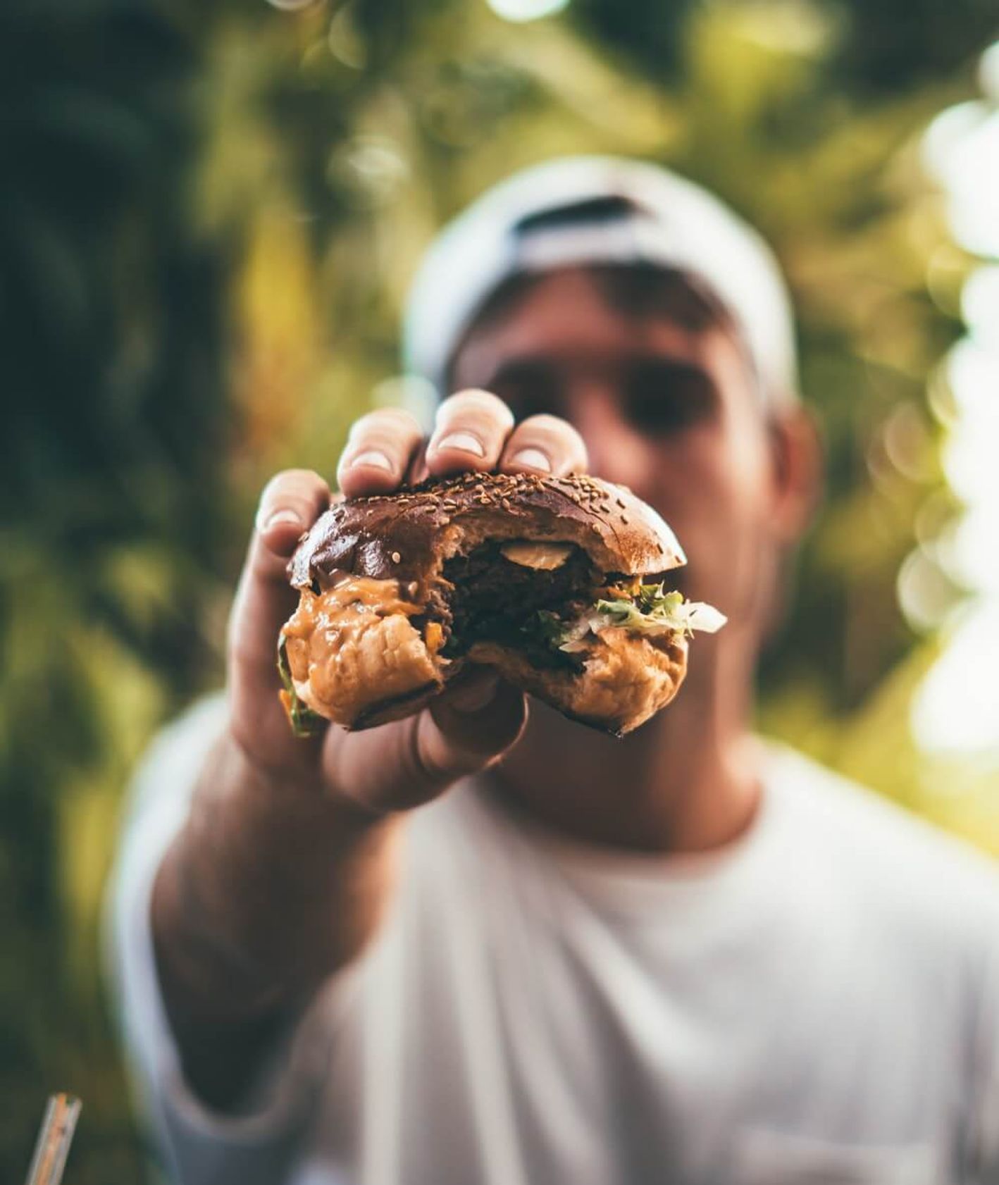 Mężczyzna z hamburgerem : Oliver Sjöström : Unsplash.com.jpg