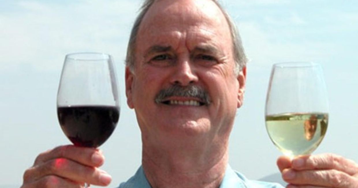John Cleese z kieliszkami białego i czerwonego wina – kadr z programu "Wino dla zdezorientowanych"