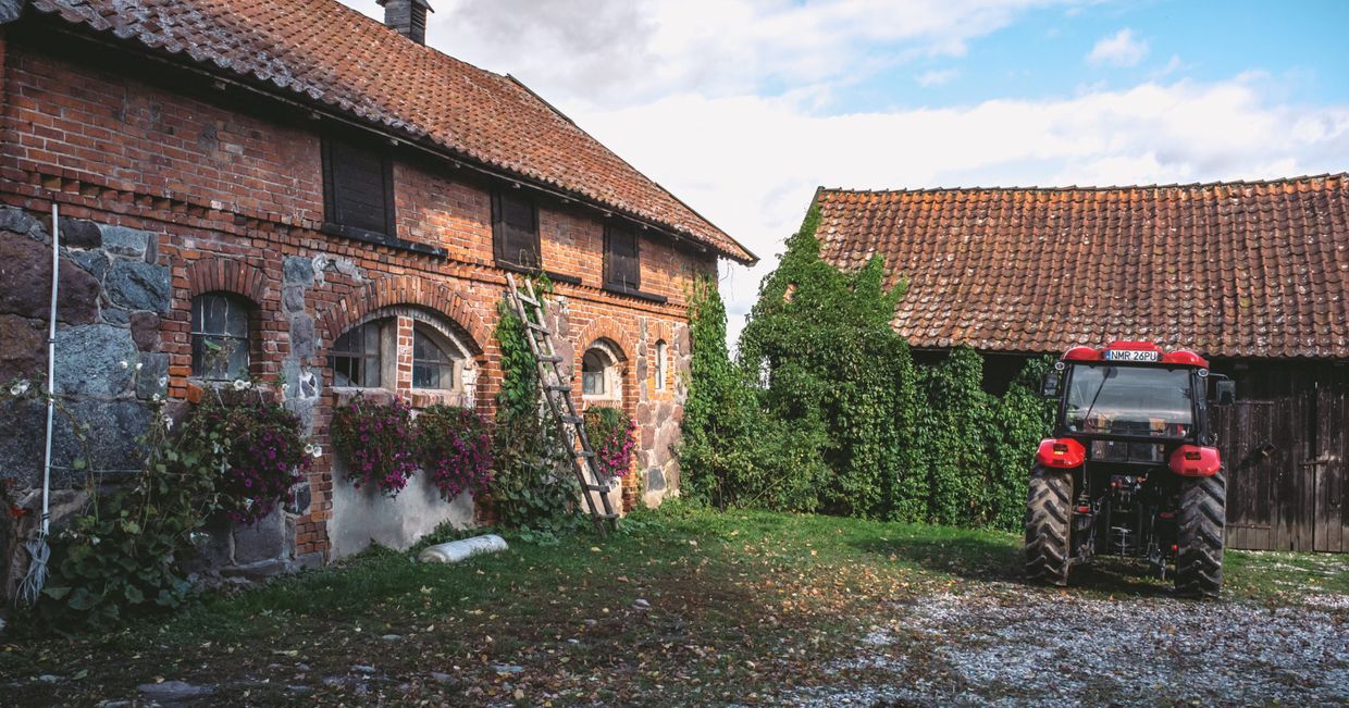 budynek gospodarstwa i stojący obok traktor