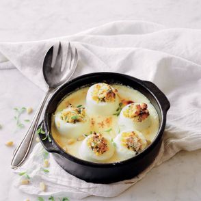 Jajka faszerowane tartym parmezanem, siekanymi orzeszkami pinii i świeżymi ziołami zapiekane w kremowym sosie serowym, przepis i zdjęcie Anna Chwistek