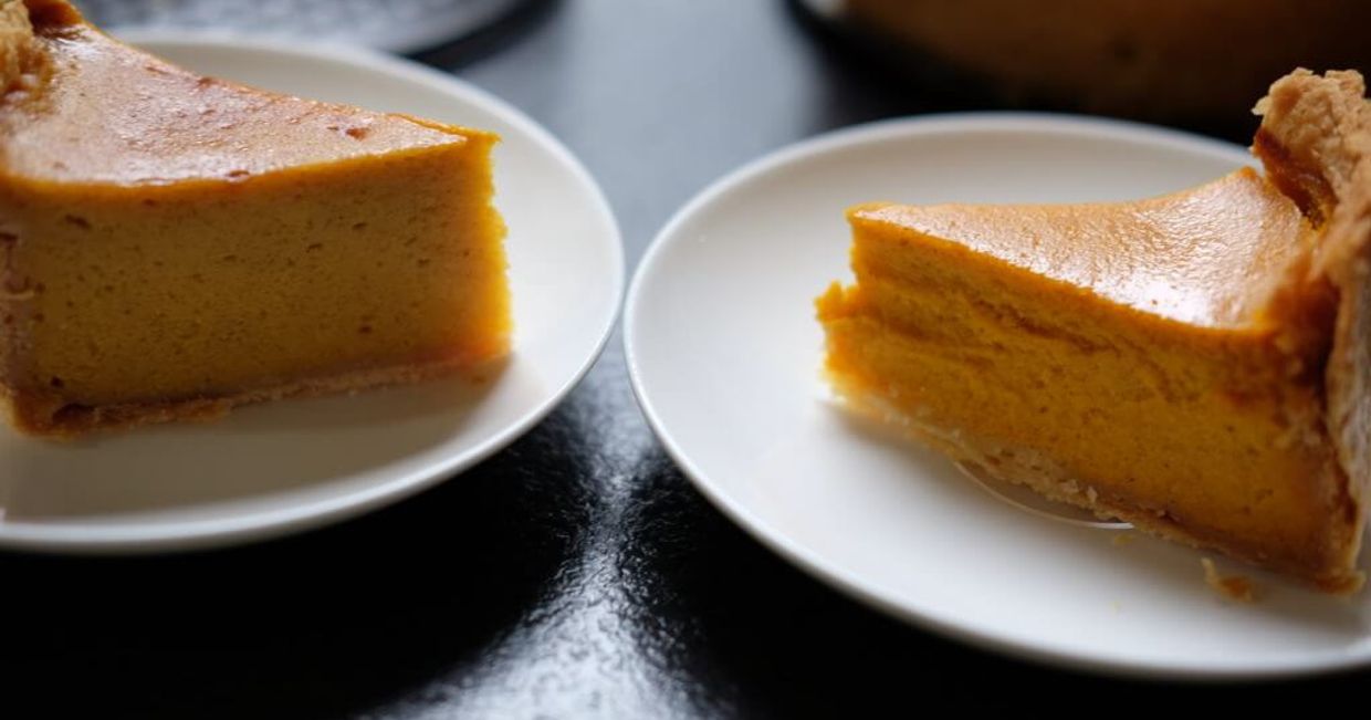 Dwa kawałki tarty dyniowej na talerzykach