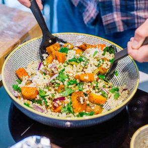 Właściciel restauracji Tomek, miesza w ceramicznej misie składniki sałatki z kaszy bulgur z dynią, czerwoną cebulą, zielonymi oliwkami i kolendrą (fot. Michał Lichtański)