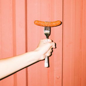 Ręka trzymająca widelec z wegańską parówką (fot. Yasin Aribuga / unsplash.com)