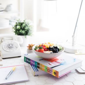 książka kucharska z położoną na niej miską owoców