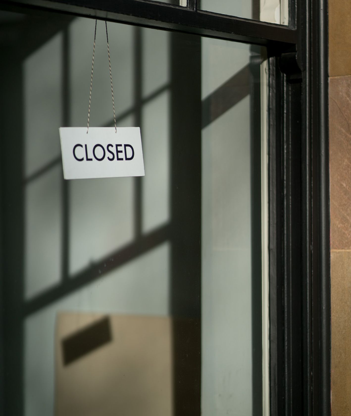 Napis zamknięte po angielsku (Closed) na zamkniętych drzwiach restauracji (fot. Craig Whitehead / unsplash.com)