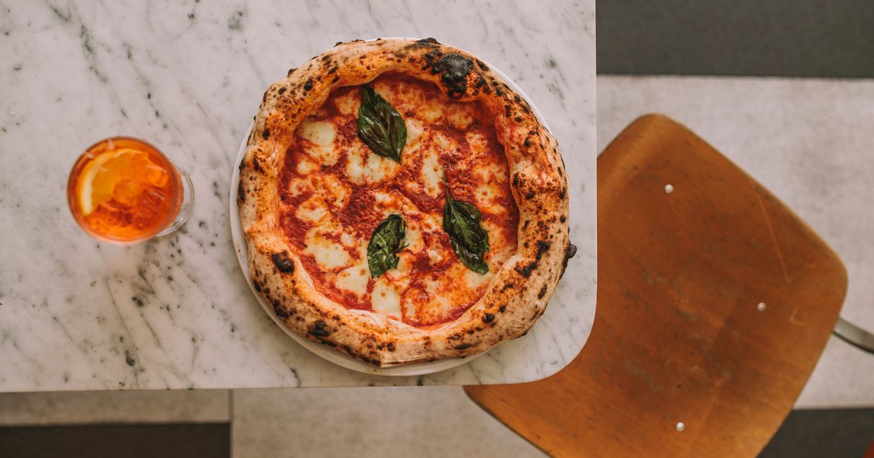 Pizza z bazylią, krzesło, blat marmurowy