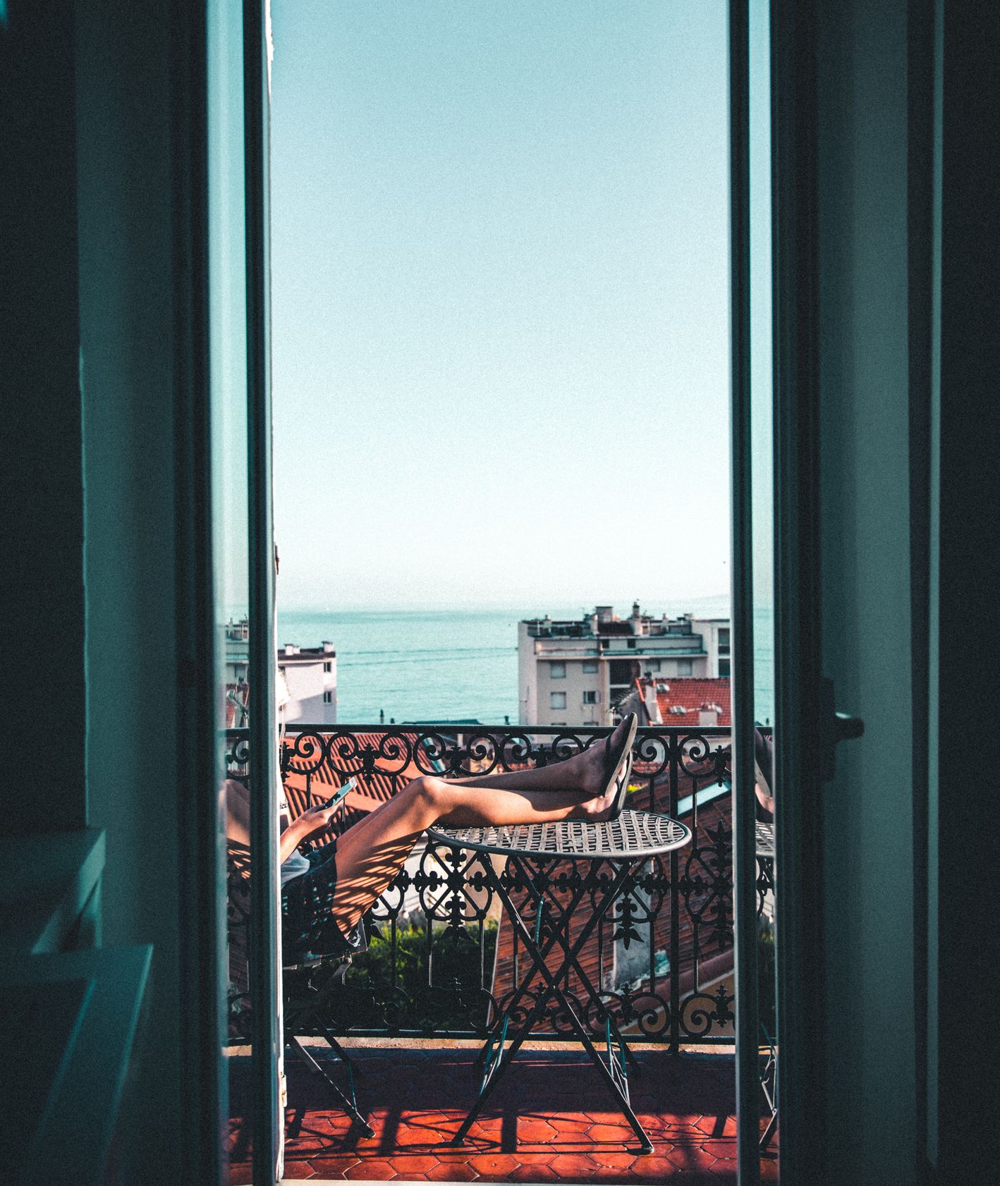 Balkon z widokiem na morze, osoba odpoczywająca na balkonie (fot. Andre Benz)
