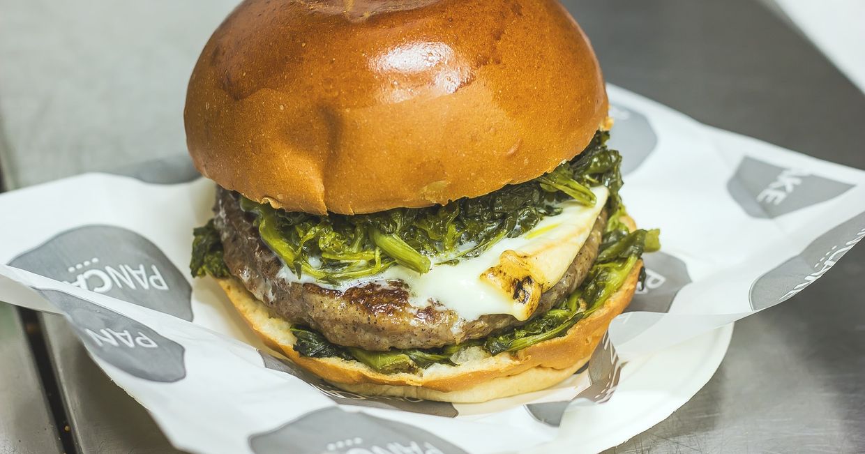 Burger na papierze z szpinakiem, smażonym mięsem, serem i majonezem (fot. Wine Dharma / unsplash.com)