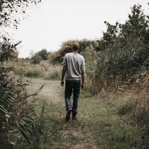 Mężczyzna idący ścieżką między roślinami (fot. Isaac Mehegan / unsplash.com)