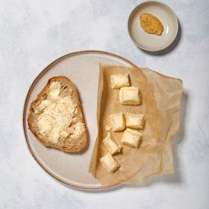 Pikantne masło musztardowe na kanapki podane na kromce domowego chleba pszennego