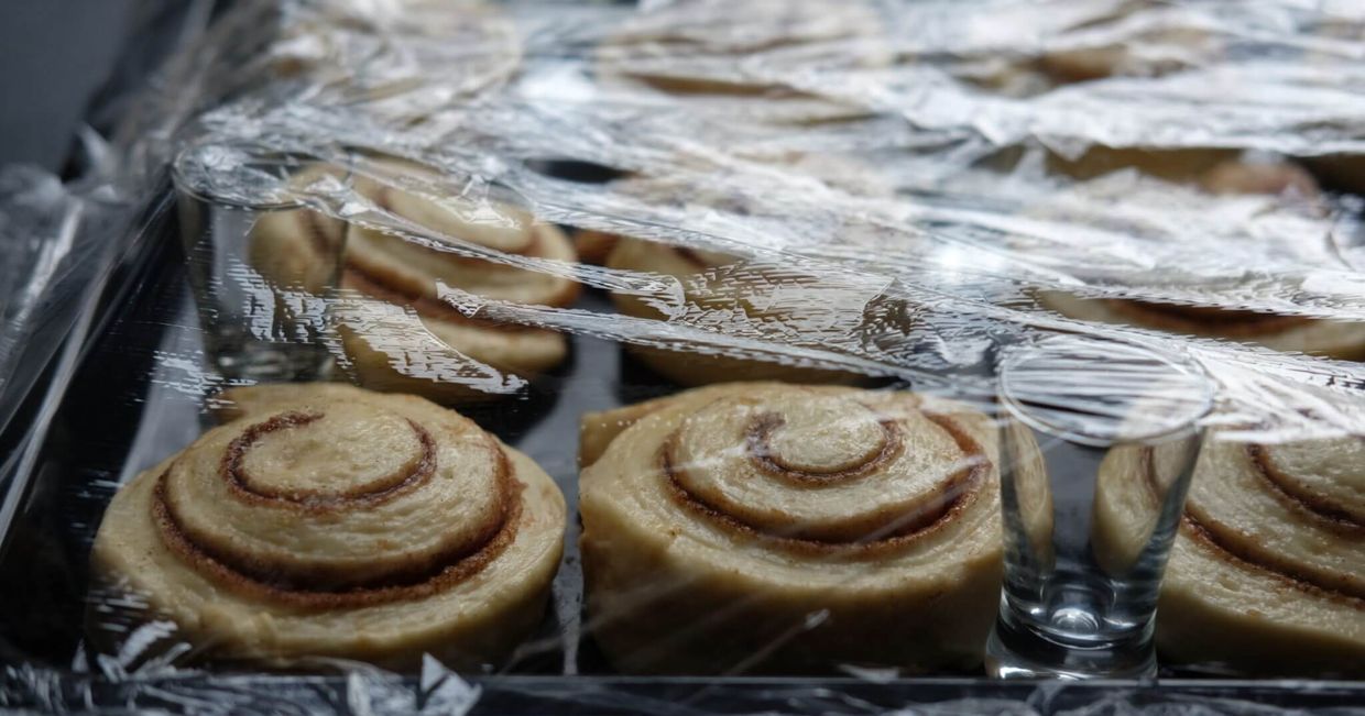 Przed pieczeniem bułeczki cynamonowe trzeba przykryć folią (fot. Kasia Stadejek)