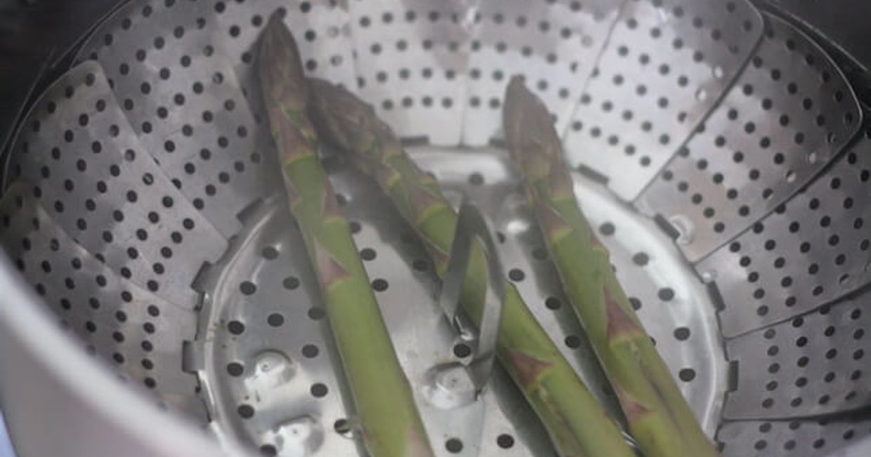 Zielone szparagi w durszlaku.