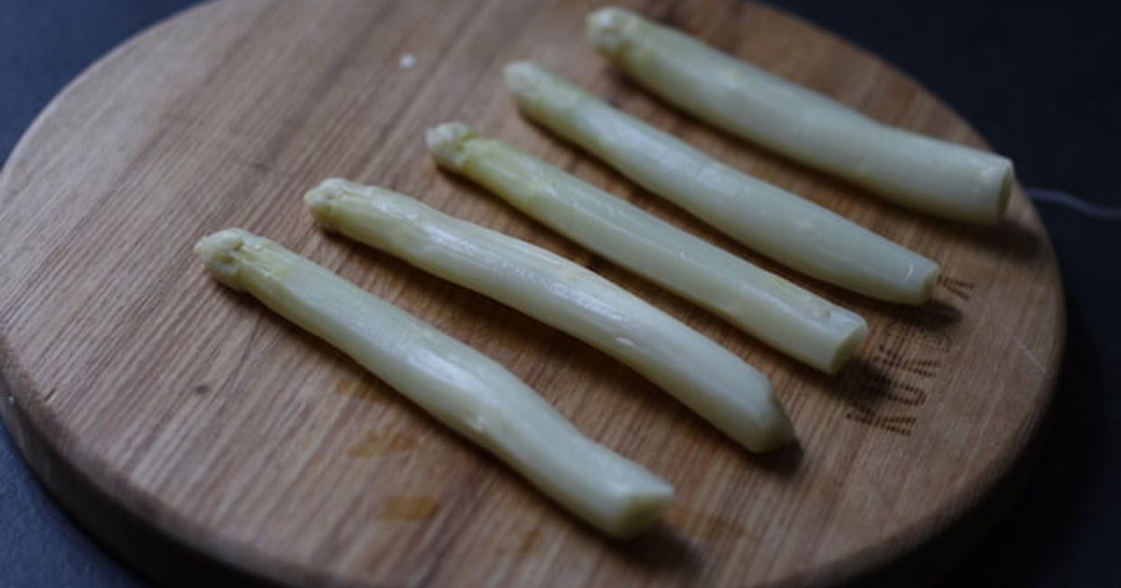 Białe szparagi na desce.